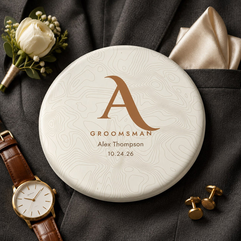 Groomsman gift disc golf disc with gold topographic monogram, name and wedding date, on a charcoal suit jacket