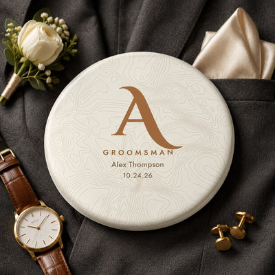 Groomsman gift disc golf disc with gold topographic monogram, name and wedding date, on a charcoal suit jacket